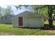 View of the detached garage with red door, white garage door and worn white siding at 5831 Aho Dr, Avon, IN 46123