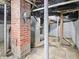 Unfinished basement featuring exposed brick and a furnace at 600 S Vine St, Muncie, IN 47302