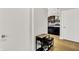 Hallway with hardwood floors leading to a kitchen with modern appliances at 622 E 10Th St # 312, Indianapolis, IN 46202