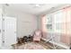 Bright bedroom with light walls, wood floors, pink drapes, and a cozy sitting area at 6301 Prospect St, Indianapolis, IN 46203