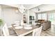 Open-concept dining area with modern chandelier, flowing into the living room and bedroom at 6301 Prospect St, Indianapolis, IN 46203