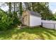 Shed in backyard featuring green grass and surrounded by trees at 6301 Prospect St, Indianapolis, IN 46203
