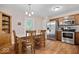 Dining area next to kitchen with wood table and chairs, stainless steel appliances, and natural light at 6333 Pinebark Pl, Indianapolis, IN 46217