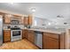 Kitchen with stainless steel appliances, wooden cabinets, and a view of the adjacent living area at 6333 Pinebark Pl, Indianapolis, IN 46217