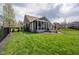 Well-manicured backyard showcasing a screened porch, patio area, and manicured lawn, creating a private outdoor space at 6784 W May Apple Dr, McCordsville, IN 46055