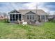 Well-maintained backyard features a screened-in porch, stone patio, and lush lawn, perfect for outdoor living at 6784 W May Apple Dr, McCordsville, IN 46055