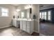 Bright bathroom featuring a double vanity with a large mirror and wood-style tile flooring at 6784 W May Apple Dr, McCordsville, IN 46055