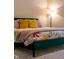 Close up on stylish bedroom with a green bedframe, floral bedding and decorative pillows at 6784 W May Apple Dr, McCordsville, IN 46055