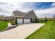 Exterior view highlighting a spacious driveway leading to a two-car garage and landscaped surroundings at 6784 W May Apple Dr, McCordsville, IN 46055