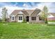 Traditional brick home with manicured lawn, mature trees, and inviting front entrance, showcasing classic curb appeal at 6784 W May Apple Dr, McCordsville, IN 46055