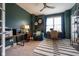 Inviting office space featuring a comfortable chair, work desk with dark green walls and a striped rug at 6784 W May Apple Dr, McCordsville, IN 46055