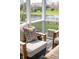 Cozy screened-in porch with wicker chairs and view of backyard and pond at 6784 W May Apple Dr, McCordsville, IN 46055