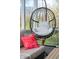 Close-up of a hanging chair and a colorful pillow on a wicker couch in a sunroom at 6784 W May Apple Dr, McCordsville, IN 46055