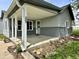 Inviting covered front porch with white pillars and gray brick-like foundation and lush landscaping at 692 S Crawford St, Martinsville, IN 46151