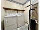 Functional laundry room with washer, dryer, overhead shelving and laundry-themed wallpaper border at 741 Springmill Dr, Mooresville, IN 46158
