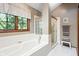 Bathroom with a large soaking tub, glass block window, and a glass enclosed shower at 742 Marana Dr, Carmel, IN 46032