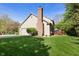 Side view of a two-story home featuring a brick chimney, attached garage, and a well-maintained lawn at 742 Marana Dr, Carmel, IN 46032