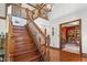 Bright foyer with hardwood floors, wooden staircase, and a view into the library at 742 Marana Dr, Carmel, IN 46032
