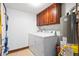 Laundry area with washer, dryer, storage cabinet, and hot water tank in a compact space at 742 Marana Dr, Carmel, IN 46032