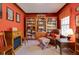 Cozy library with red walls, built-in bookshelves, and a comfortable seating area at 742 Marana Dr, Carmel, IN 46032