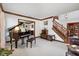 Living room with a piano, comfortable seating, and access to the staircase at 742 Marana Dr, Carmel, IN 46032