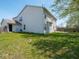 View of the house from the backyard showcasing lawn and mature trees at 7611 Penguin Cir, Indianapolis, IN 46239