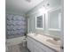 Well-lit bathroom with double sink vanity, shower with tub, and updated tile floors at 7611 Penguin Cir, Indianapolis, IN 46239