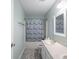 Bathroom featuring single sink vanity, shower with tub, and a patterned shower curtain at 7611 Penguin Cir, Indianapolis, IN 46239