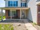 Cozy front porch with brick accents, well-maintained lawn, and front door at 7611 Penguin Cir, Indianapolis, IN 46239