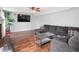 Comfortable living room featuring a ceiling fan, hardwood floors, and a cozy gray sectional sofa at 7611 Penguin Cir, Indianapolis, IN 46239