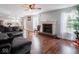 Inviting living room with a brick fireplace, hardwood floors, and a view into the modern kitchen at 7611 Penguin Cir, Indianapolis, IN 46239