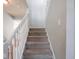 Carpeted staircase with white railing, providing a safe and stylish transition between floors in the home at 7611 Penguin Cir, Indianapolis, IN 46239