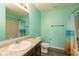 Bathroom with aqua walls, a shower with a colorful curtain, and a granite countertop at 7643 Belmac Ln, Camby, IN 46113