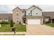 Inviting two-story home featuring a brick and gray siding exterior and an attached two-car garage at 7643 Belmac Ln, Camby, IN 46113
