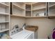 Functional laundry room with built-in shelves and a modern washing machine and dryer at 7643 Belmac Ln, Camby, IN 46113