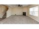 Large carpeted living room with a fireplace and staircase, bathed in natural light from a window at 7643 Belmac Ln, Camby, IN 46113