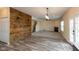 Spacious living room with a statement wood wall, leading to a staircase and featuring a fireplace at 7643 Belmac Ln, Camby, IN 46113