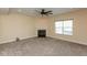 Cozy living room features a fireplace, ceiling fan, neutral carpet, and a window at 7643 Belmac Ln, Camby, IN 46113