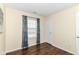 Bright bedroom featuring a window with curtains and beautiful, dark hardwood flooring at 8141 Maple Stream Ln, Indianapolis, IN 46217