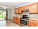 Well-lit kitchen featuring stainless steel appliances, mosaic backsplash, and sliding glass doors at 8141 Maple Stream Ln, Indianapolis, IN 46217