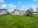 Large backyard with a patio, chain-link fence, green grass, and a playset at 8146 Whitaker Valley Blvd, Indianapolis, IN 46237