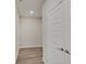 Hallway with wood floors and white walls, featuring a white door at 8593 Hudson Way, Brownsburg, IN 46112