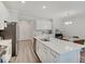 Bright, white kitchen featuring stainless steel appliances and a large center island at 8593 Hudson Way, Brownsburg, IN 46112