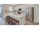 Modern kitchen with white cabinets, stainless steel appliances, and a quartz countertop island with seating at 8593 Hudson Way, Brownsburg, IN 46112