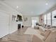 Bright living room boasts a large sofa, hardwood floors, a fireplace, and ample natural light at 8593 Hudson Way, Brownsburg, IN 46112