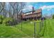 Large backyard featuring a well-maintained lawn, a black fence, and a view of the multi-level deck at 9719 Decatur Dr, Indianapolis, IN 46256