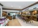 Finished basement featuring a long bar area with seating and an adjacent living room with a brick fireplace at 9719 Decatur Dr, Indianapolis, IN 46256
