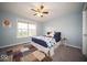 Comfortable bedroom with large window, neutral paint, ceiling fan, and plush carpet. A great space to relax at 9949 Stable Stone Ter, Fishers, IN 46040