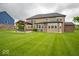 Stunning home exterior showcasing a spacious yard, a covered patio with elegant furnishings, and ample natural light at 9949 Stable Stone Ter, Fishers, IN 46040