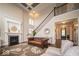 Bright living room featuring fireplace, hardwood floors, staircase, and elegant decor with neutral paint at 9949 Stable Stone Ter, Fishers, IN 46040